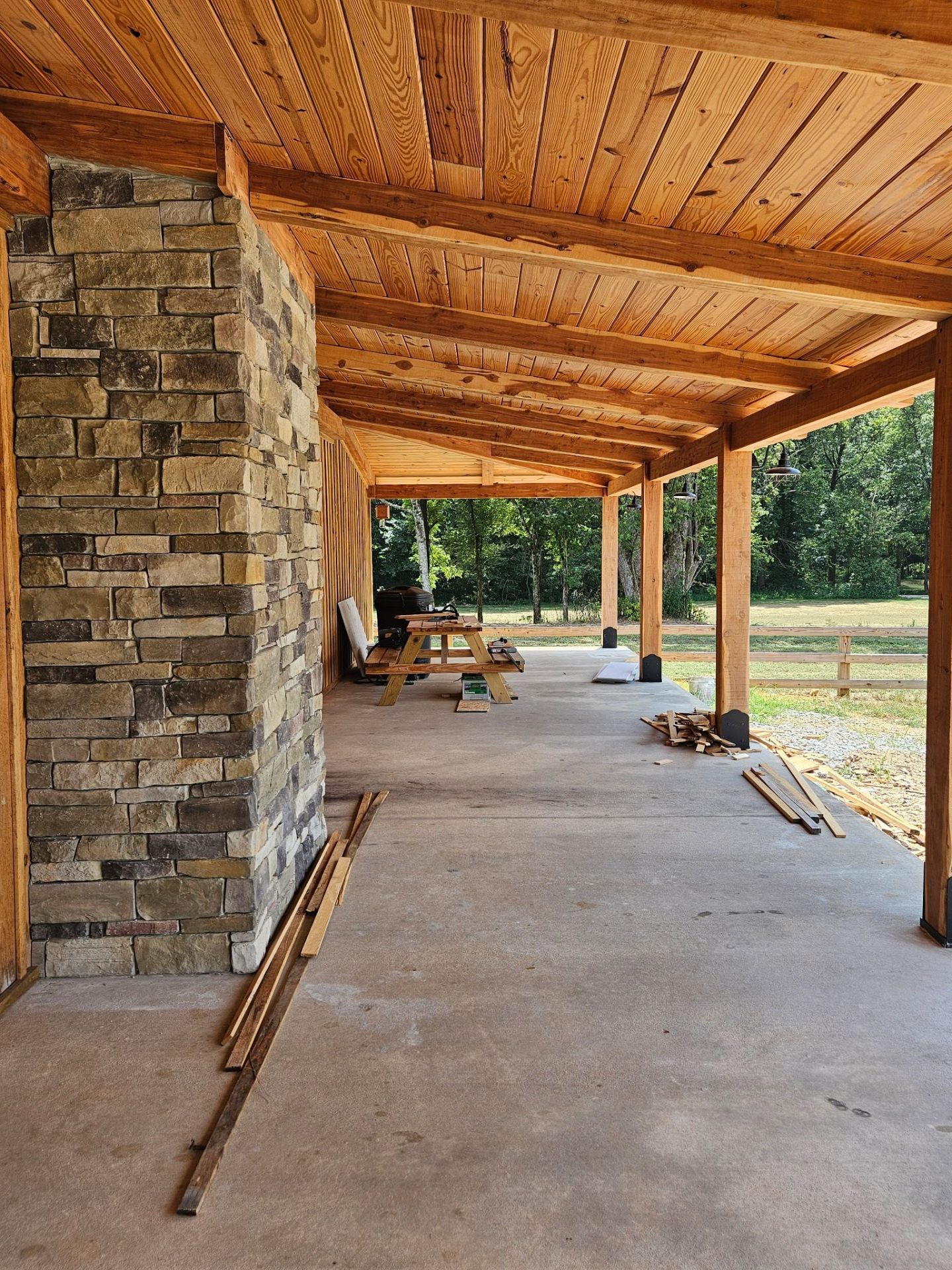 Lean-to pavilion with tongue-and-groove ceiling, stone column, and exposed timber rafters