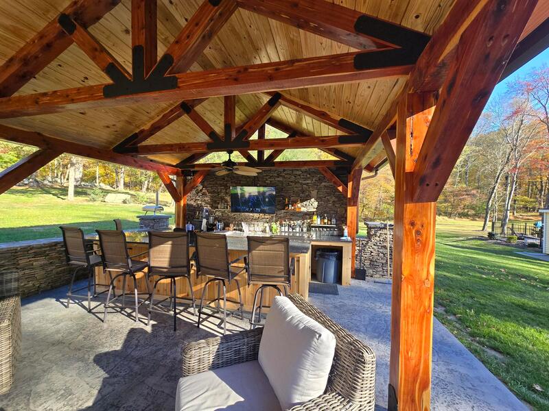 Stained Cypress pavilion with metal roof and patio furniture